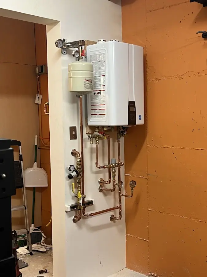 Plumbing technician inspecting water heater connections in Arden Hills